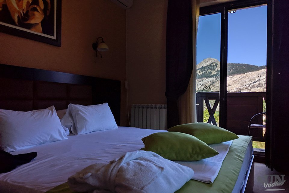 Bedroom with double bed and a balcony with a beautiful views of the mountains at Lovcen National Park